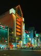 热血冒险类番剧封面，主角手持武器站在废墟城市前，橙色夕阳光线渲染强烈战斗氛围，与acg盒子热血动漫分类高度契合